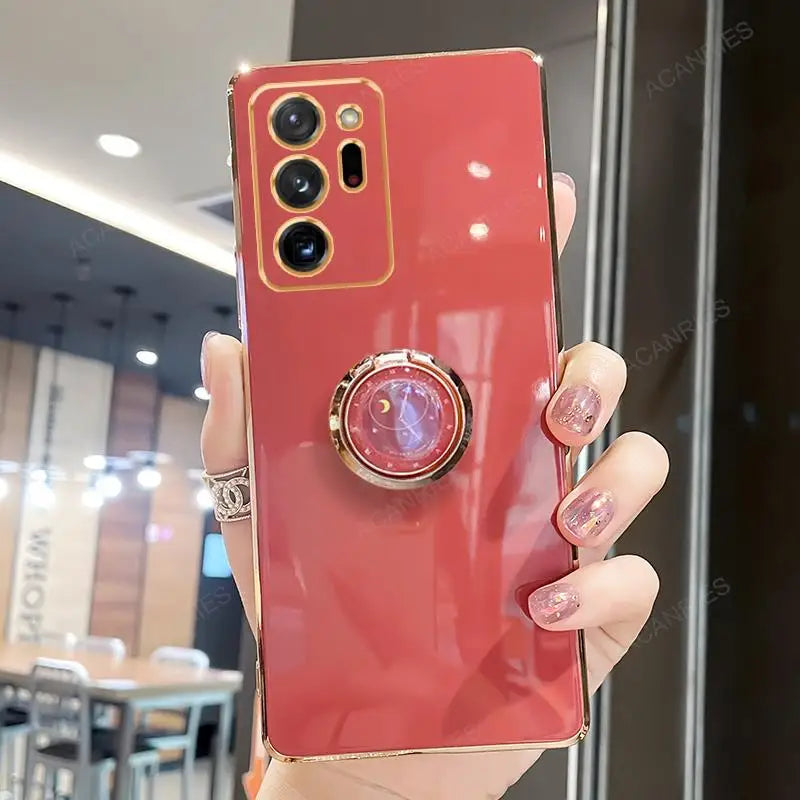 Samsung Galaxy Note20, Note10, Note9 phone case with built-in ring stand, gold-plated, from Corporación Turística, showing front and ring detail.