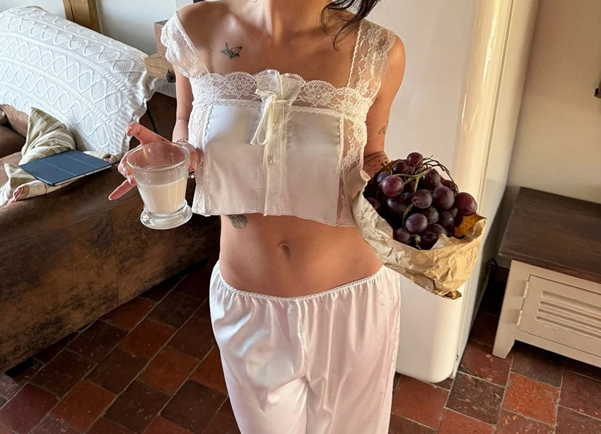 Two-piece top and pants set from Corporación Turística featuring elegant lace details, displayed on a mannequin.