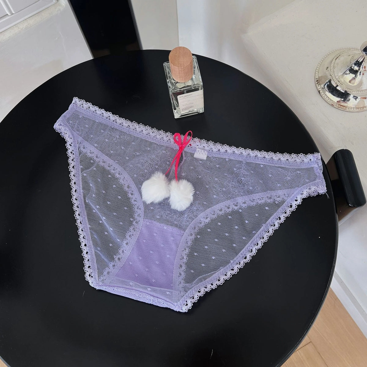 Transparent mesh panties with decorative bow from Corporación Turística, featuring delicate lace and feminine design.