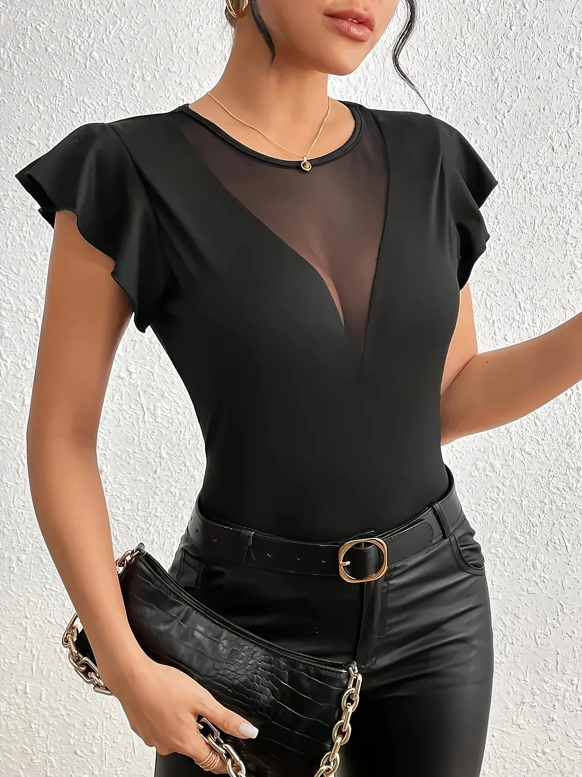 Body sexy con escote profundo en V, transparencias y manga larga, de Corporación Turística, en imagen elegante y seductora.