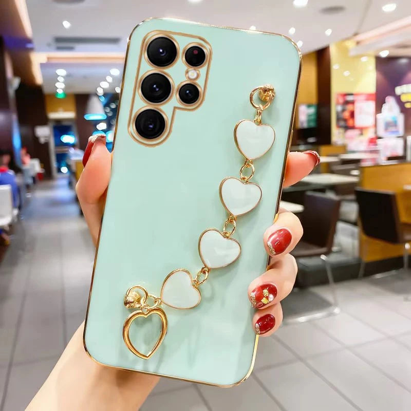 Silver heart phone case with chain from Corporación Turística, stylish protective cover featuring a decorative heart and chain detail.