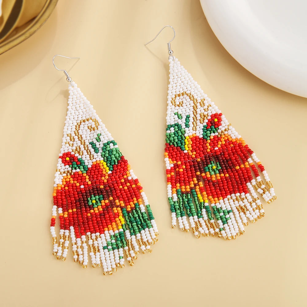 Bohemian style earrings with three-dimensional design and tassel details by Corporación Turística, featuring vibrant, decorative accents.