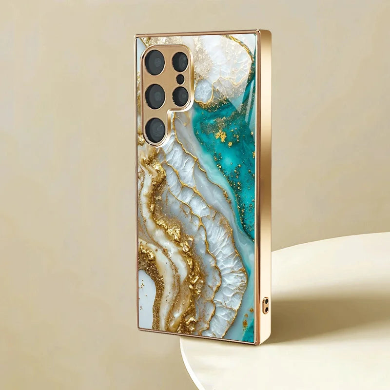 Silver metallic glass phone case with artistic painted design for smartphones, featuring a sleek protective cover.