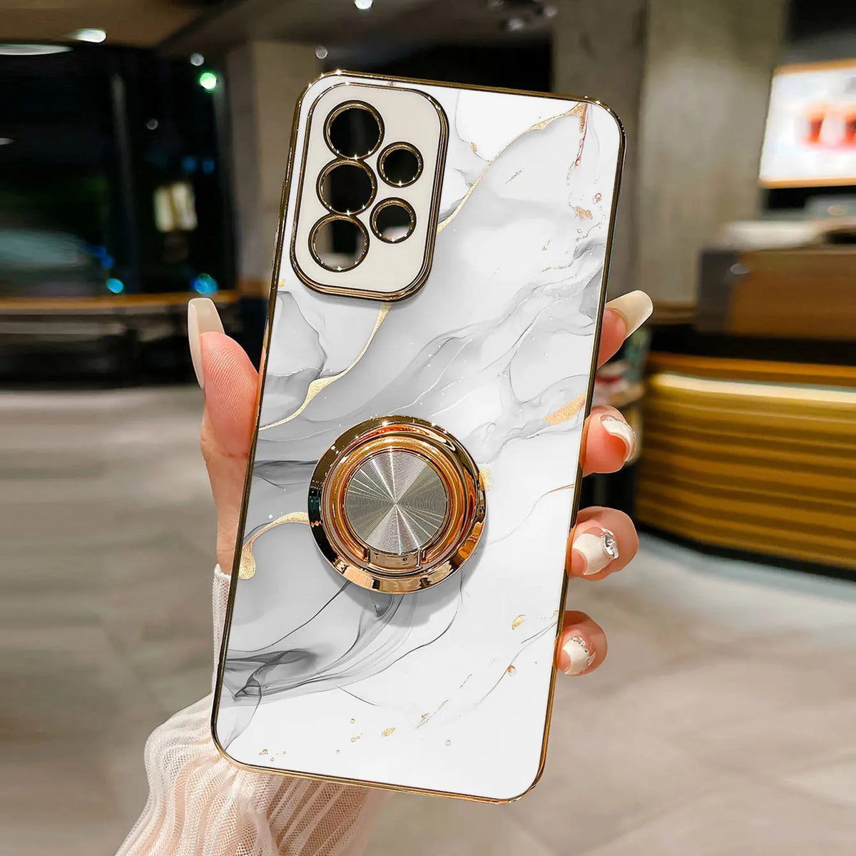 Phone case with ring holder featuring a marble pattern, designed by Corporación Turística, shown with the ring stand on the back.
