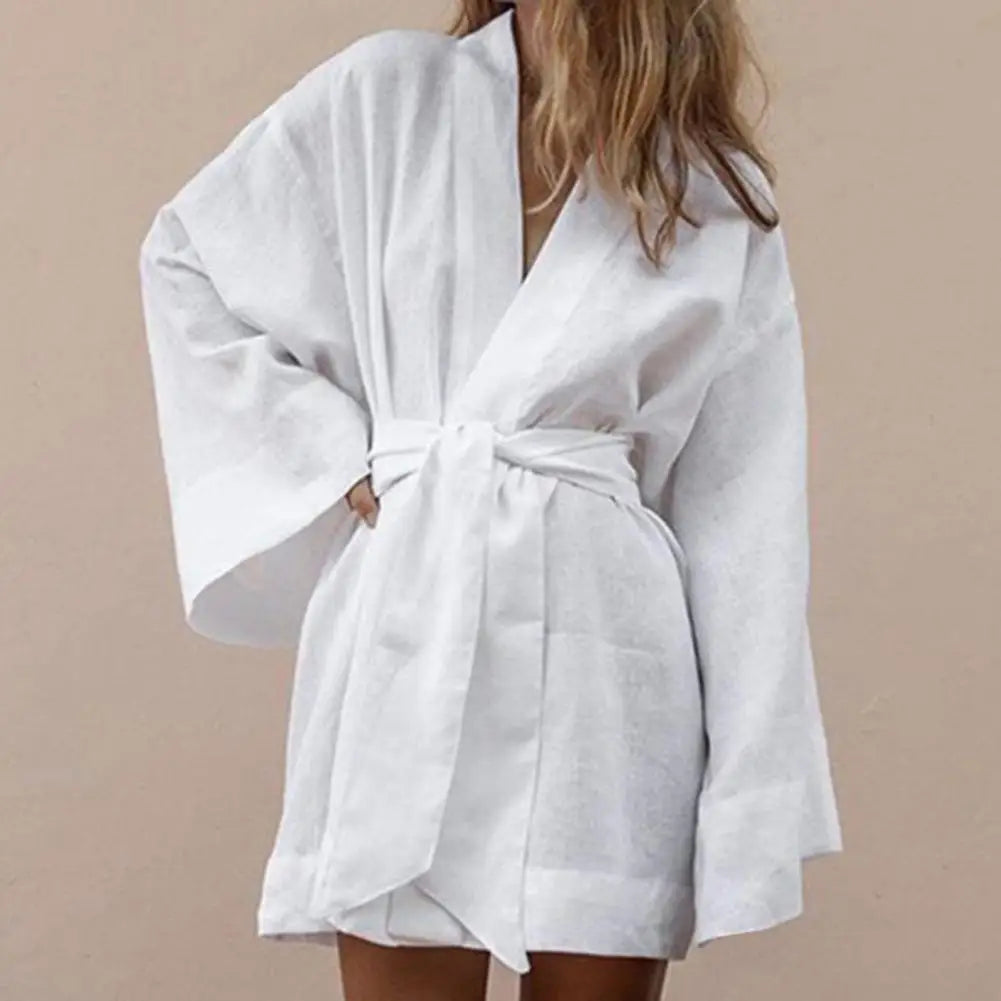 Long-sleeve V-neck minidress with drawstring details, stylish design by Corporación Turística, shown in a fashion photo.