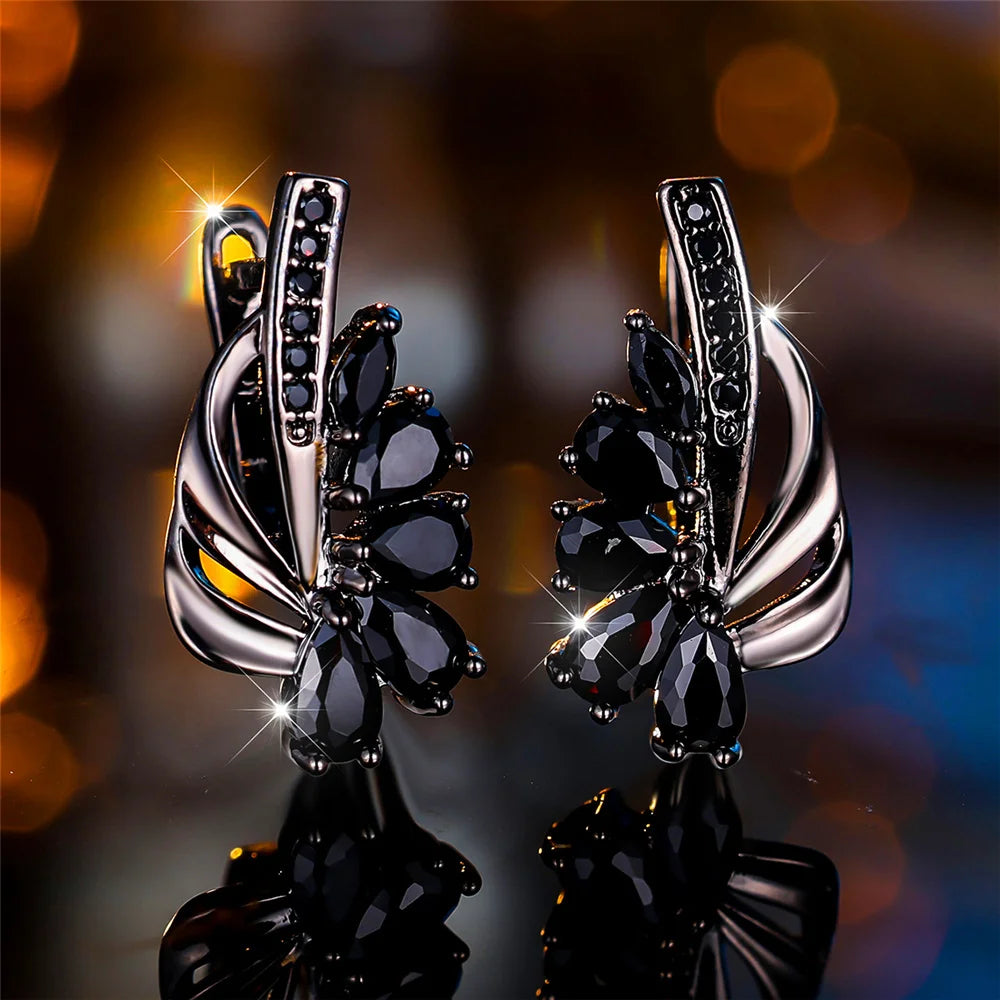 Luxury clip-on earrings for women featuring green and blue gemstones, elegant and stylish jewelry from Corporación Turística.