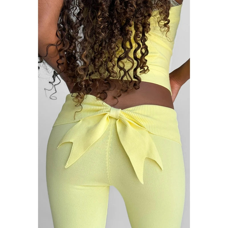 Long flared knit pants by Combhasaki Y2L, stylish and comfortable, shown in a natural pose with soft fabric details.
