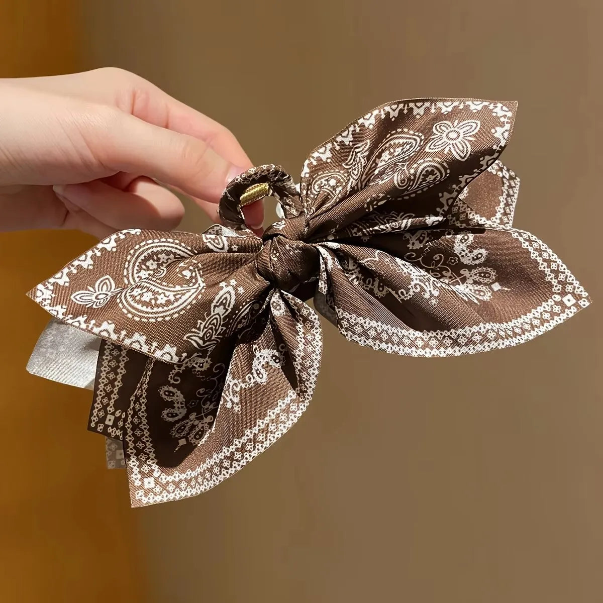 Hair clip with floral bow in soft fabric, perfect for styling or accessorizing; made by Corporación Turística.
