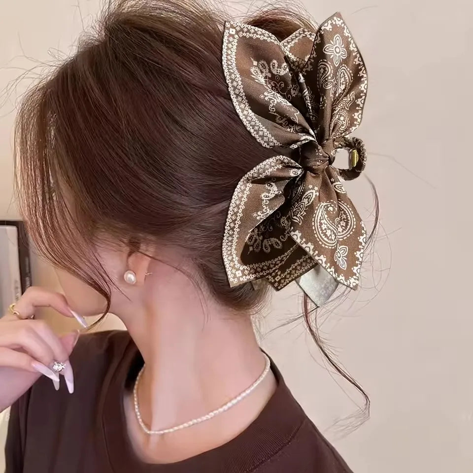Pink floral bow hair clip with velvet texture, decorative flower embellishment, ideal for styling and accessorizing hair.