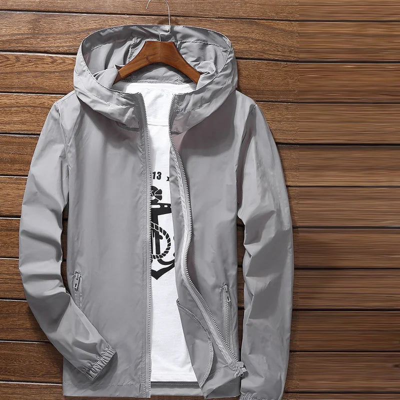Lightweight quick-dry cycling and running jacket by Corporación Turística, shown in black with a hood and reflective details.