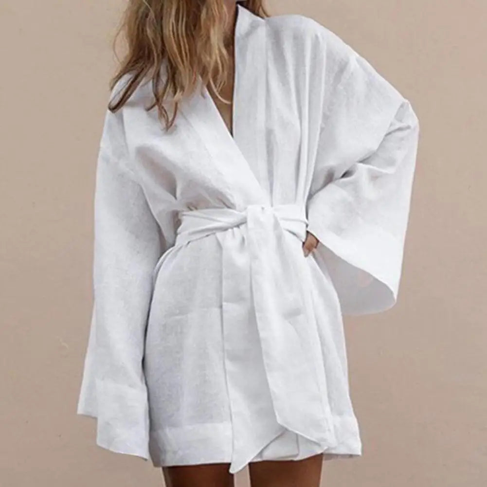 Long-sleeve V-neck mini dress with drawstrings from Corporación Turística, showing the front view in soft fabric.