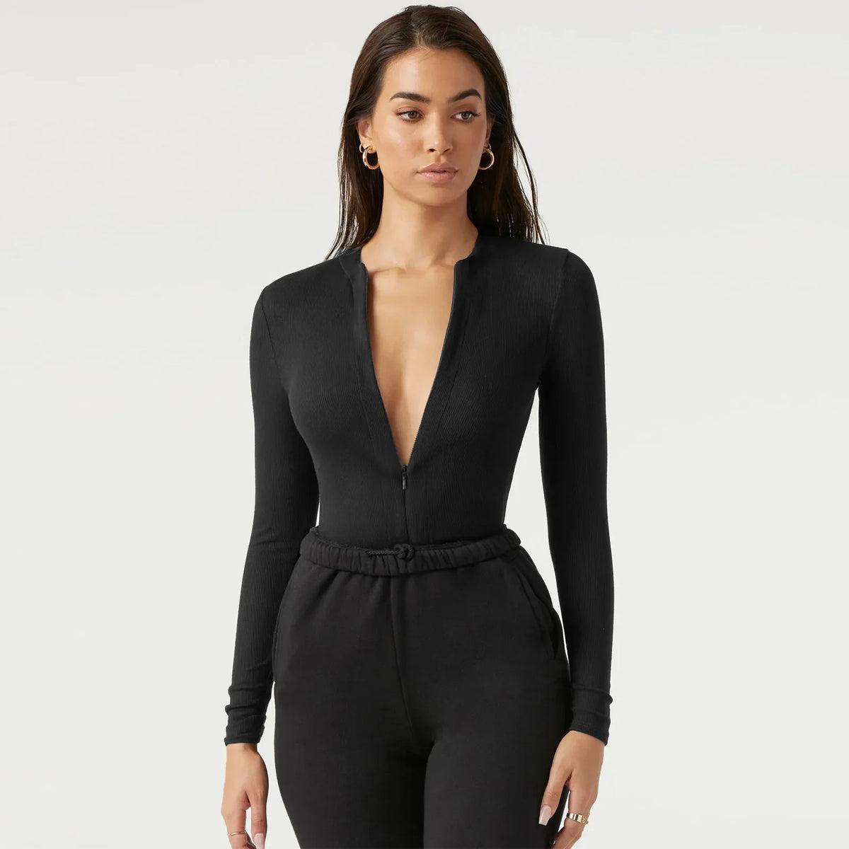 Long-sleeve cream-colored ribbed women's jumpsuit by Corporación Turística, shown on a model.