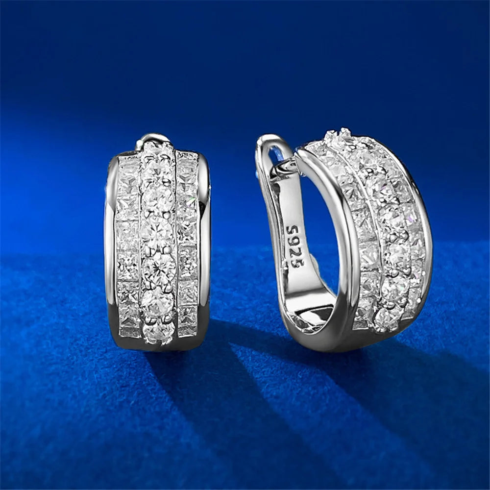 Silver hoop earrings with sparkling white cubic zirconia stones, round design, by Corporación Turística.