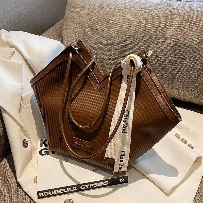 Large Korean-style women's canvas tote bag with sturdy handles, featuring a casual and versatile design.