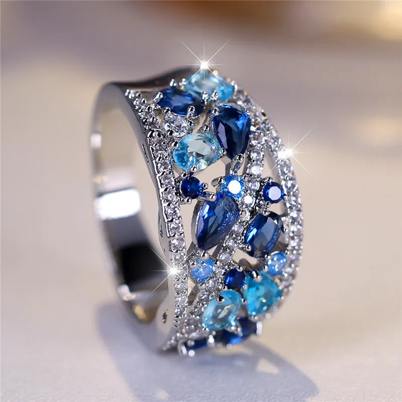 Elegant silver ring with a large blue zircon gemstone for women, featuring intricate design details.