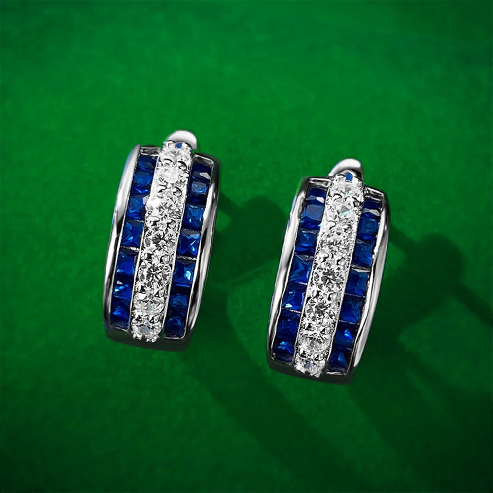 Silver hoop earrings with white cubic zirconia stones, round design, from Corporación Turística.