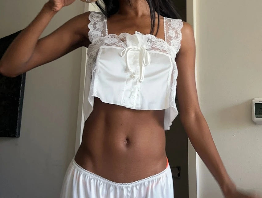 Two-piece set featuring a lace top and matching pants from Corporación Turística, shown on a mannequin.