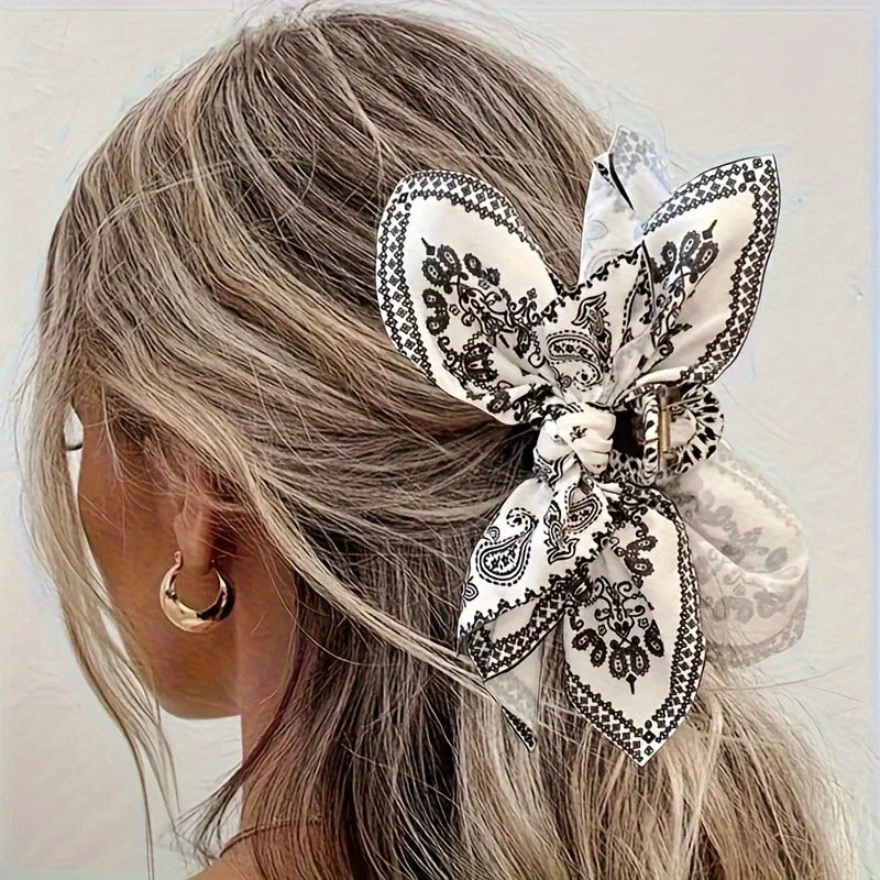 Elegant hair clip with a floral bow design, made of fabric, from Corporación Turística, perfect for styling and accessorizing hair.