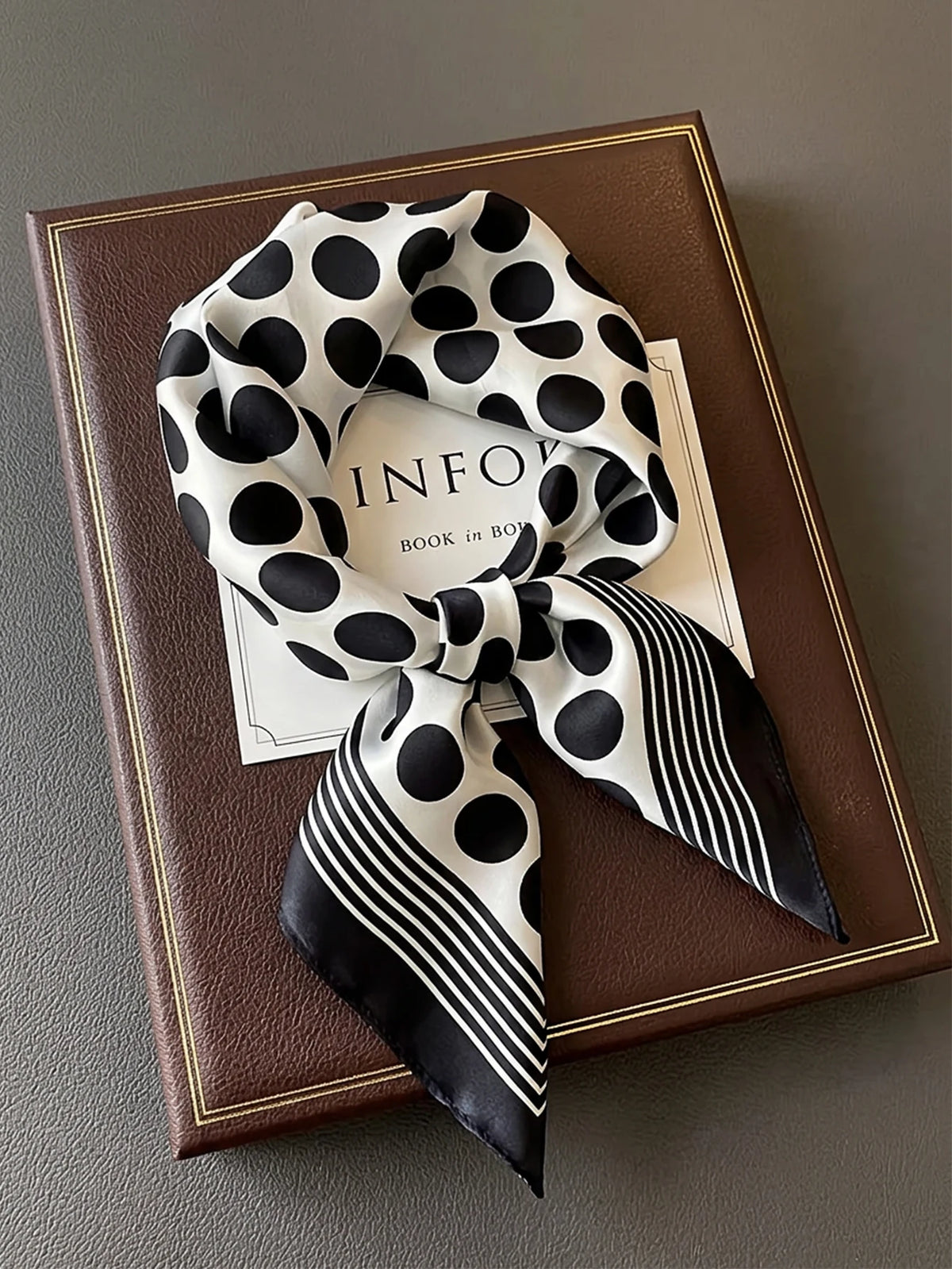 Square silk-look scarf by Corporación Turística, featuring a patterned design in vibrant colors.