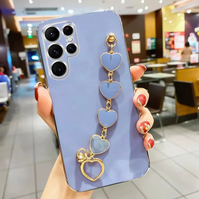 Fashion phone case with silver heart charm and chain, stylish protective cover for smartphones by Corporación Turística.
