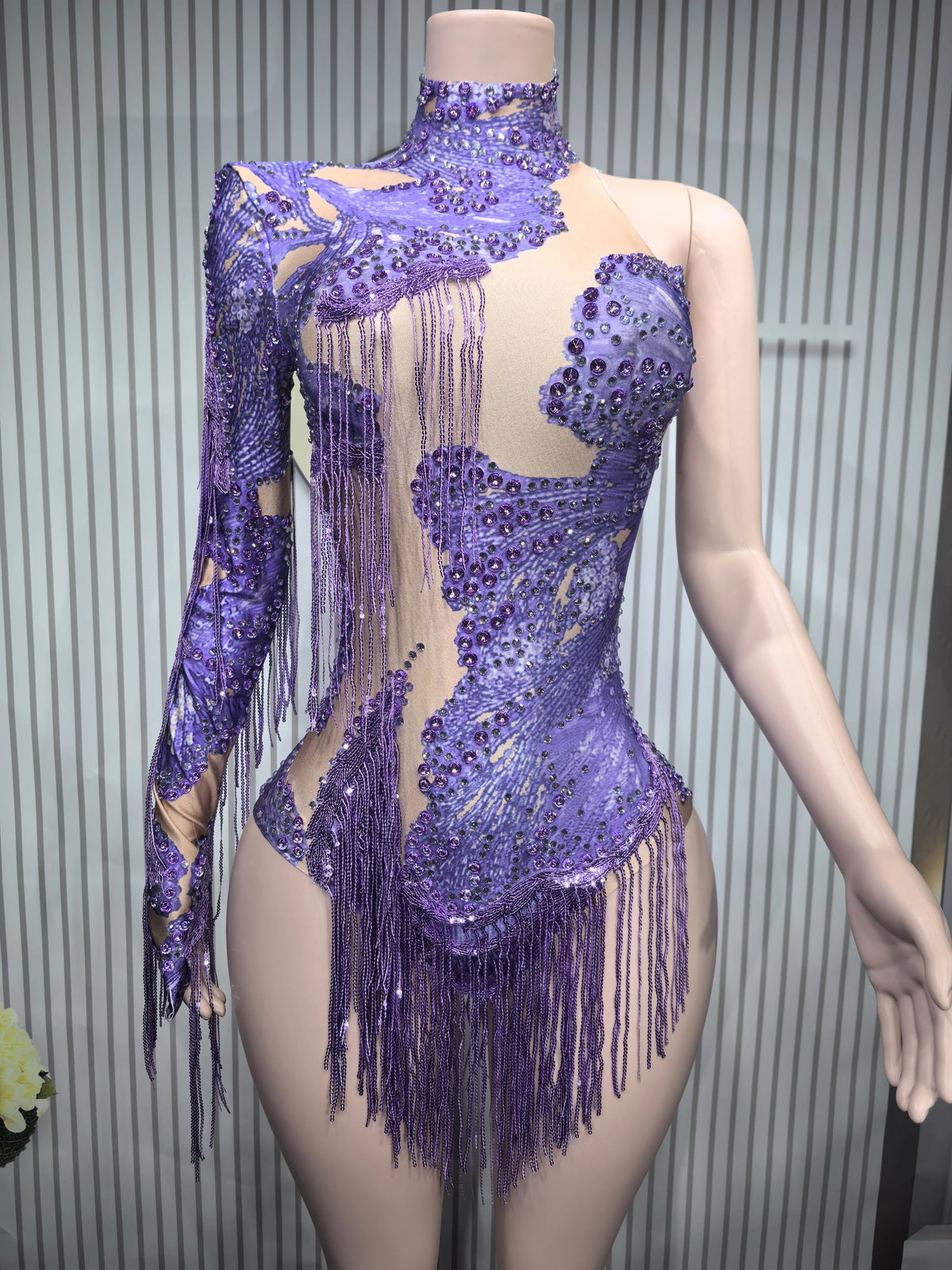 Close-up of a fitted sexy women's leotard dance costume with fringe details, designed for performance and movement.
