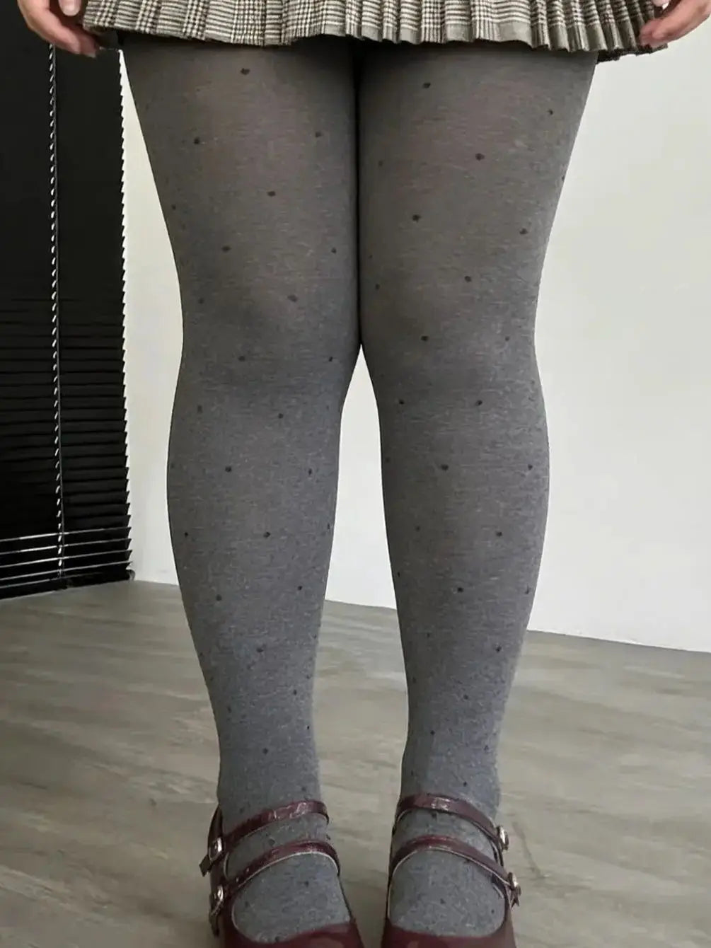 Gray vintage knit tights with small polka dots from Corporación Turística, showing close-up of the textured fabric and pattern.