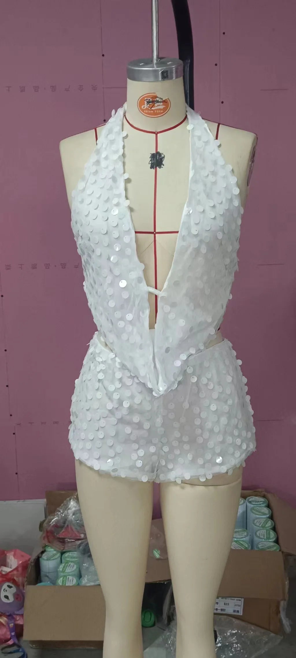 Sexy two-piece sequin outfit with sleeveless top, vibrant and shiny, designed for stylish evening wear and special occasions.