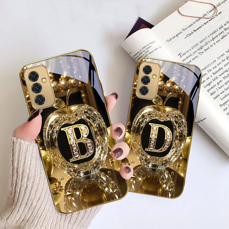 Golden crystal phone case with letter 'A' from Corporación Turística, featuring a shiny finish and decorative design.