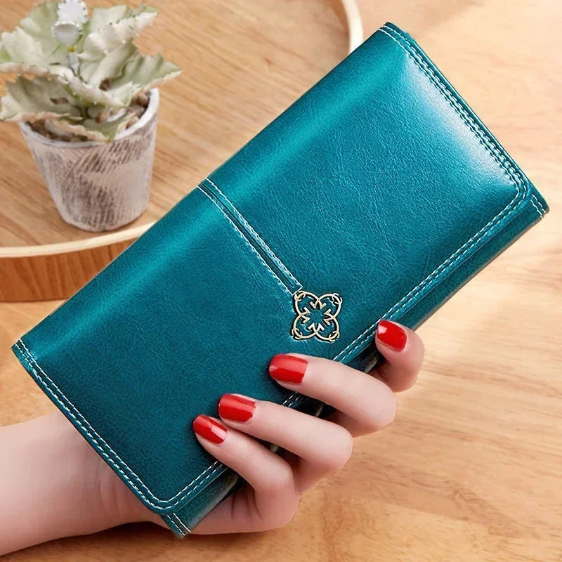 Long women's leather wallet by Corporación Turística featuring card slots and a coin pocket, shown in black leather.