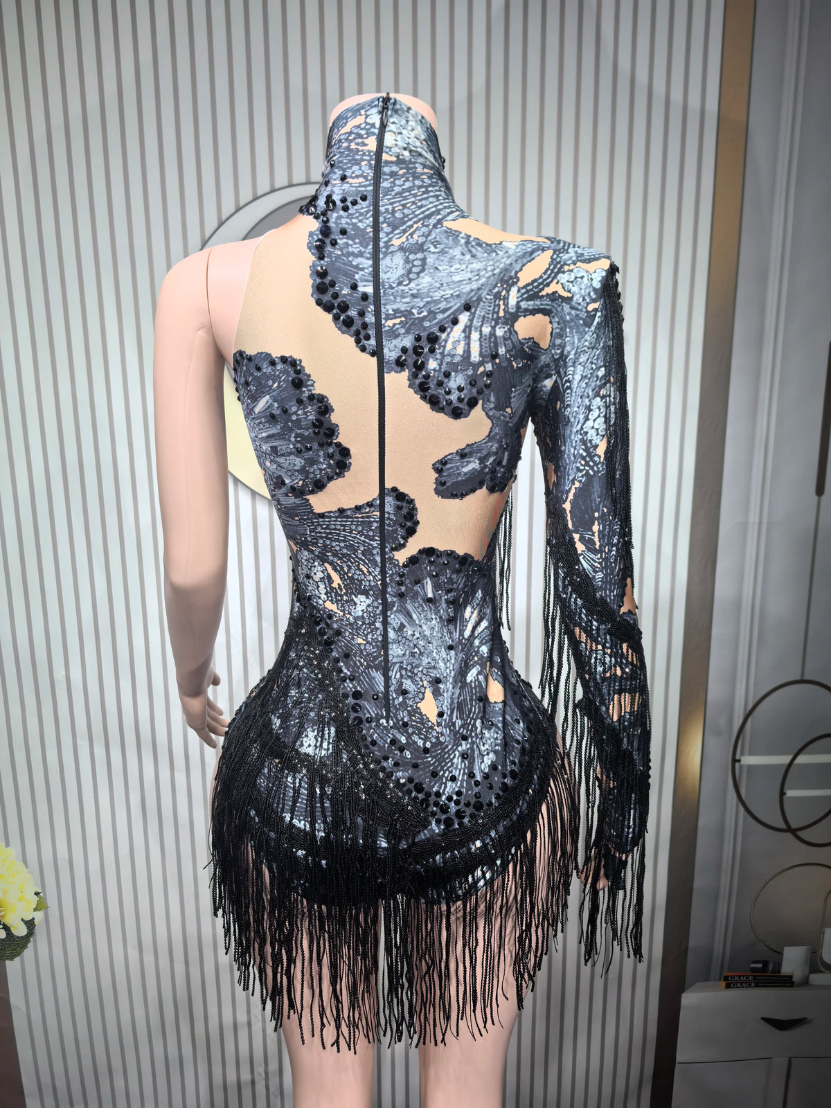 Close-up of a fitted sexy women's leotard for dance with decorative fringes, showcasing sleek design and vibrant fabric.