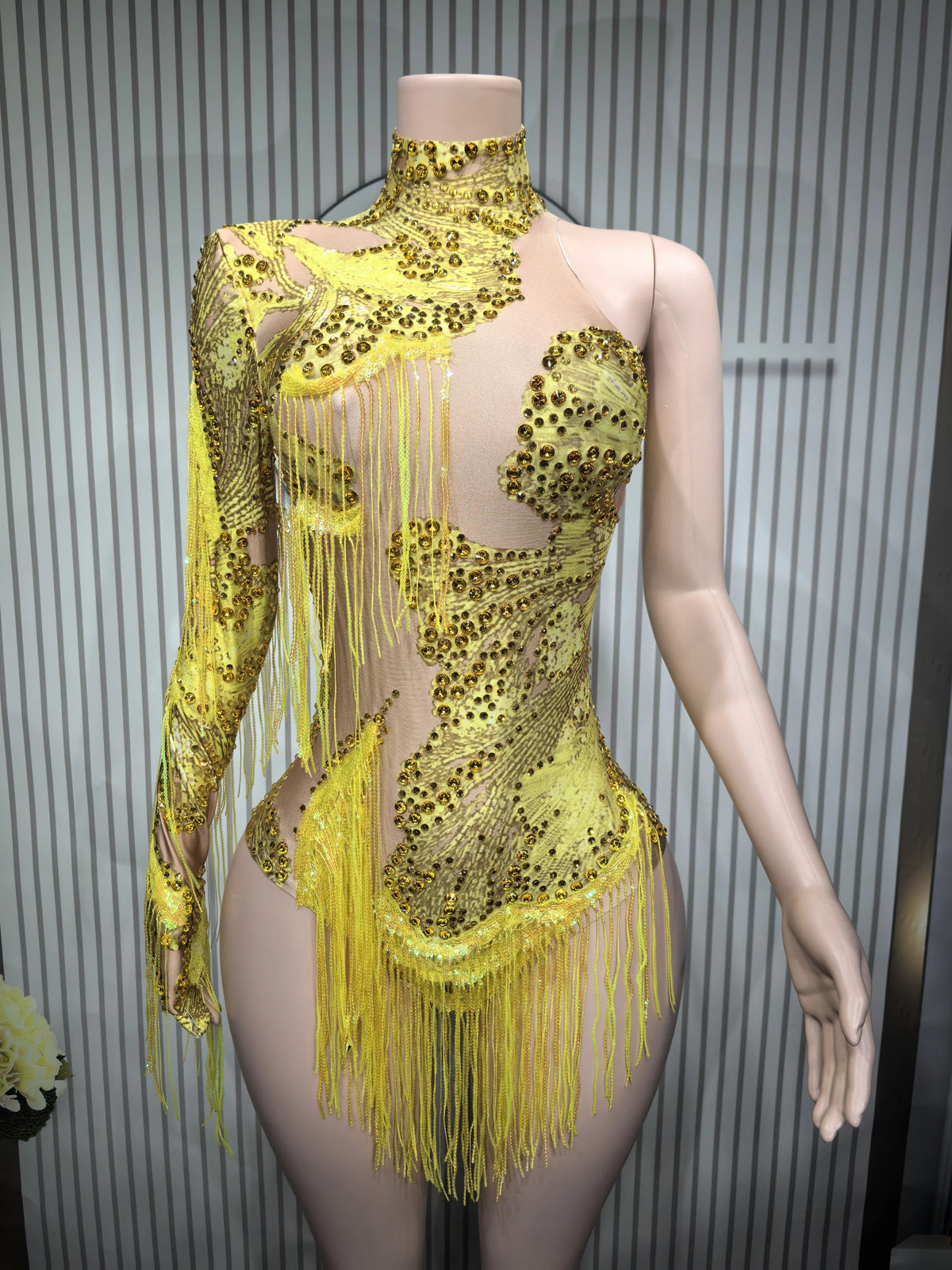 Fitted sexy women's dance leotard with fringe details, made by Corporación Turística, shown on a model in a dance pose.